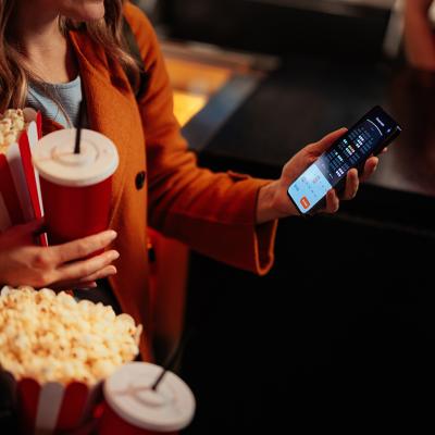 A young woman checking seats in a theater using a mobile app.