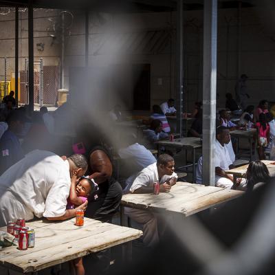 An inmate gives his daughter a hug and kiss during Father's Day at Joe Kegans State Jail's visiting hall.