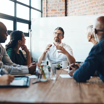 A manager leading a team meeting in a boardroom.