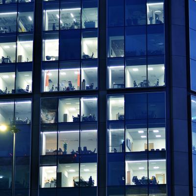 Glass facade of a modern corporate building during night.
