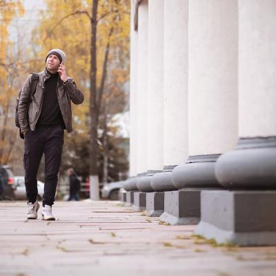 A man walking through the city during autumn.