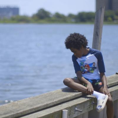 A boy looking out over Jamaica Bay in the Edgemere neighborhood of New York City.