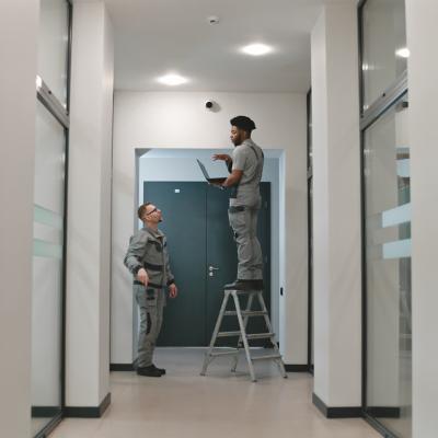 Two installation workers setting up a surveillance camera.