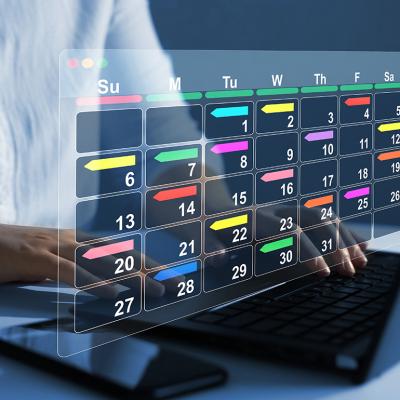 Person using a laptop with graphics of a digital calendar.