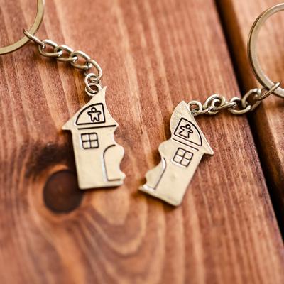 Two halves of a home keyholders as a concept of property sale after divorce.