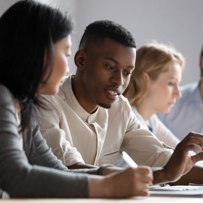 Colleagues seated at a desk in a co-working room.