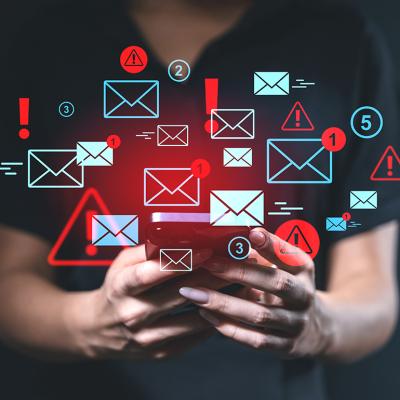 Person using a smartphone illustrated with blue and red email alert graphics.