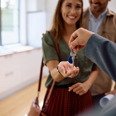 A real estate agent handing over house keys to a new couple.