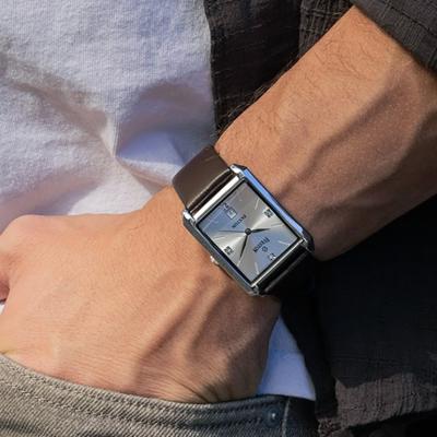Close up on a man's wrist sporting a square watch.