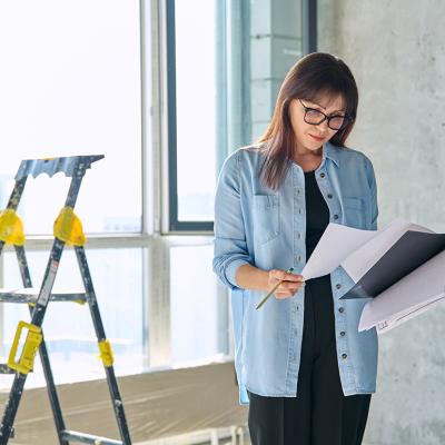 A female interior designer reviewing an apartment renovation plan.