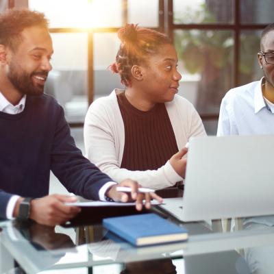 Three members of a business team brainstorming on strategy in an office.