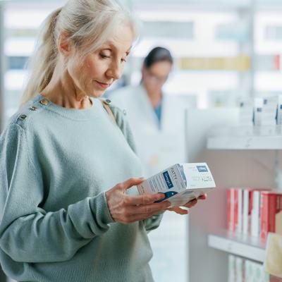 A senior woman buying a product at the pharmacy.