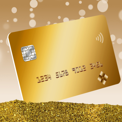 A gold credit card is seen in a pile of gold dust with bokeh circles in the background in a 3D illustration.