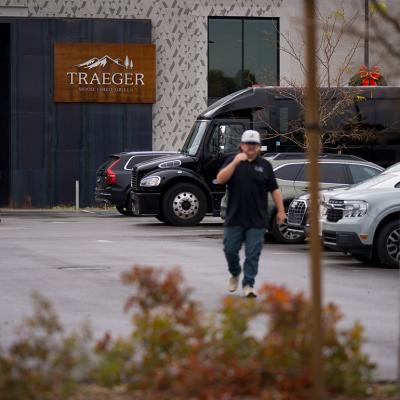A person walking through the parking lot in the foreground with entrance to Traeger Grills Headquarters in behind, in Salt Lake City.