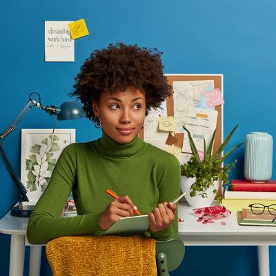 A young woman writing down plans in her notepad.