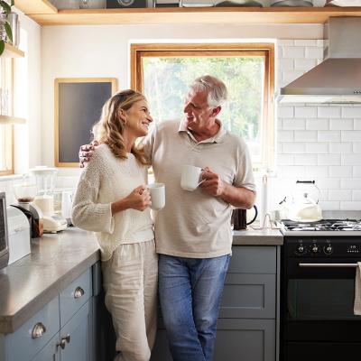 A middle-aged couple having a coffee in their kitchen.