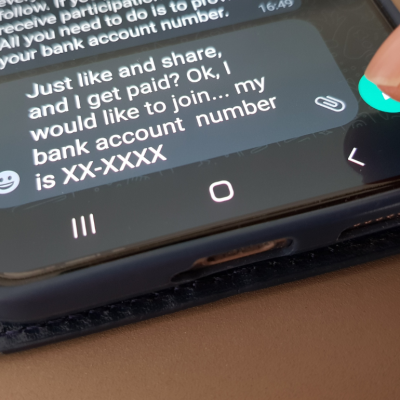 A person about to hit send to a message on their phone that says, "Just like share, and I get paid? Ok, I would like to join, my bank account number is XX-XXXX."