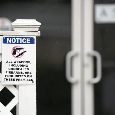 A sign prohibiting firearms at Willie's Bar & Grill posted on the fence outside in St. Helena Island, South Carolina. 