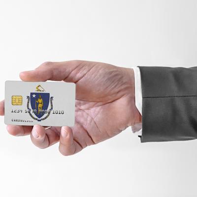 A person's hand holding a credit card designed with the flag of Massachusetts.