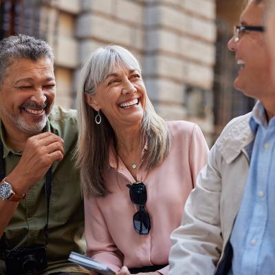 A group of senior friends laughing together on a day out.