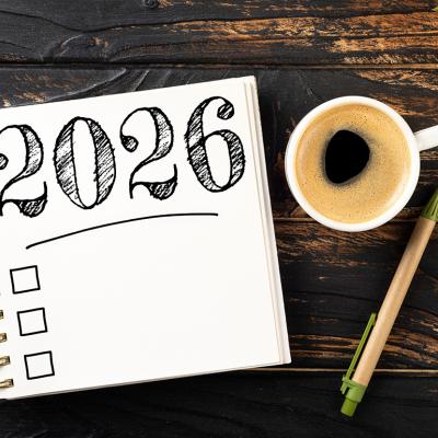A notebook with a 2026 checkbox with a pen and a cup of coffee on a desk.