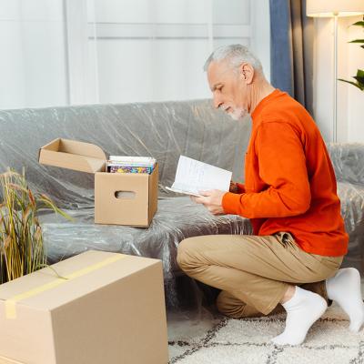 A senior man unpacking boxes of belongings when moving to a new home.