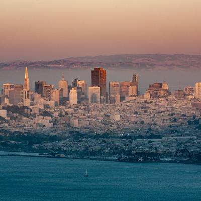 A foggy view of the San Francisco skyline during sunset.