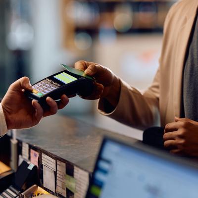 Person taps credit card on a payment terminal at a hotel.