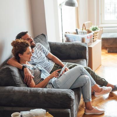 A couple sitting together on a sofa at home