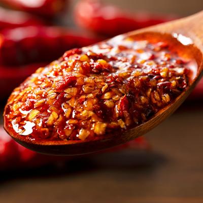 Chili oil scooped up with a wooden tablespoon.