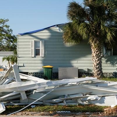 Debris on the side of a street after a hurricane in a residential area in Florida.