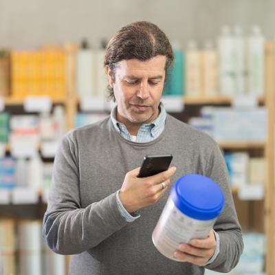 A man scanning a baby food's information while shopping.