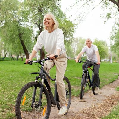 A senior couple riding bikes in a park.