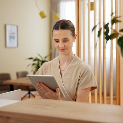 A female front desk staff at a spa using a digital tablet to look at schedule.