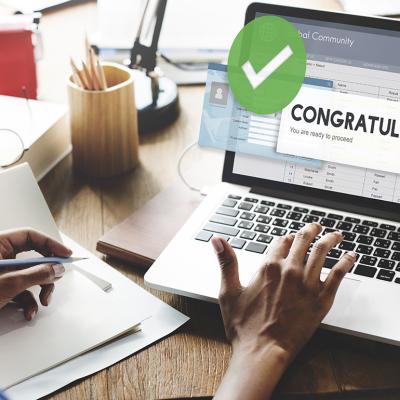 A female jobseeker opening an application with a 'congratulations' message using a laptop.
