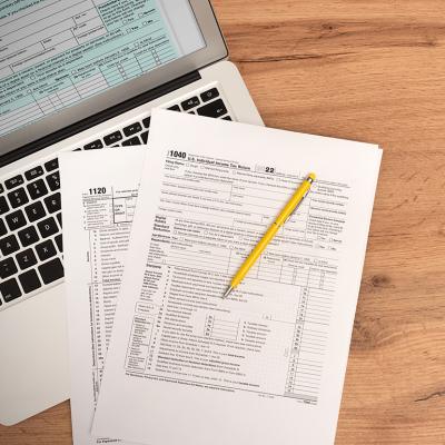 US tax form documents on top of a laptop.