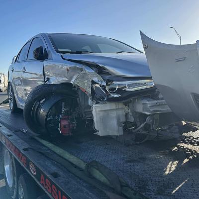 A crashed car loaded on a tow truck.