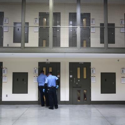 Guards prepare to escort an immigrant detainee from his 'segregation cell' back into the general population at the Adelanto Detention Facility on November 15, 2013 in Adelanto, California.