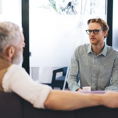 A young businessman listening to his senior manager.