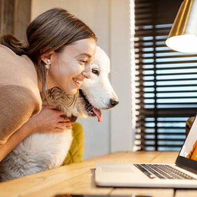 A young woman sharing a video call with her dog at home.