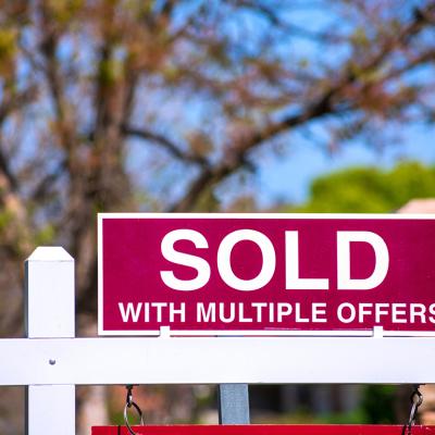 A 'sold with multiple offers' sign for a property.