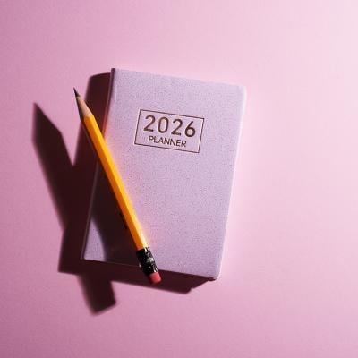 A pink 2026 planner with a pencil against a pink background.