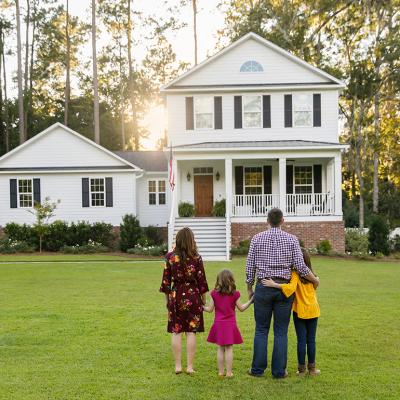 A family of four looking at their newly-constructed home.