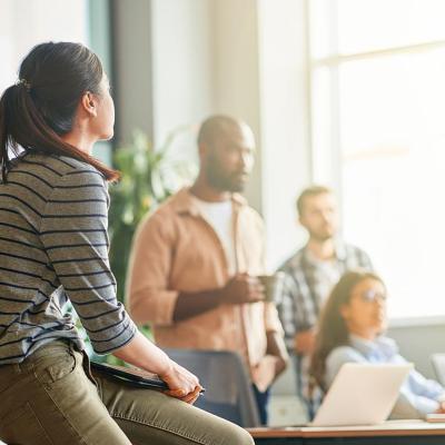 A young woman looking at her business team during a meeting in an office.