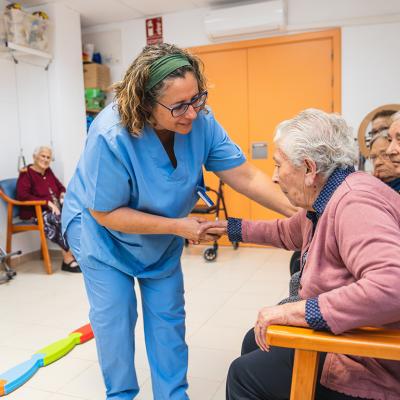 A nurse assisting one of the elderly residents of a nursing home.