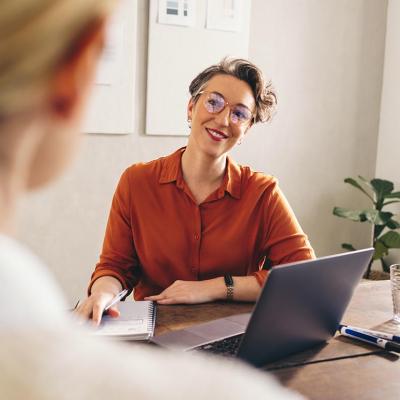A female hiring manager happily interviewing a job candidate.
