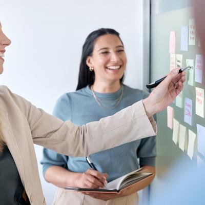 A business team planning for a project using sticky notes on a board.