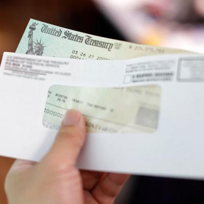 Person holding a tax refund check from government.