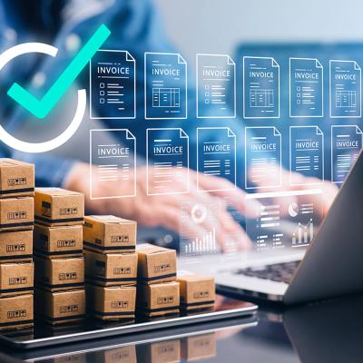 Businessperson using a laptop with small boxes of inventory on the side, illustrated with electric invoice software graphics.