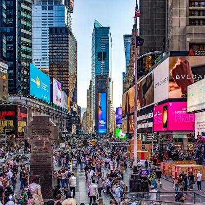 Crowds of people and lit up billboards around Times Square in New York City. 